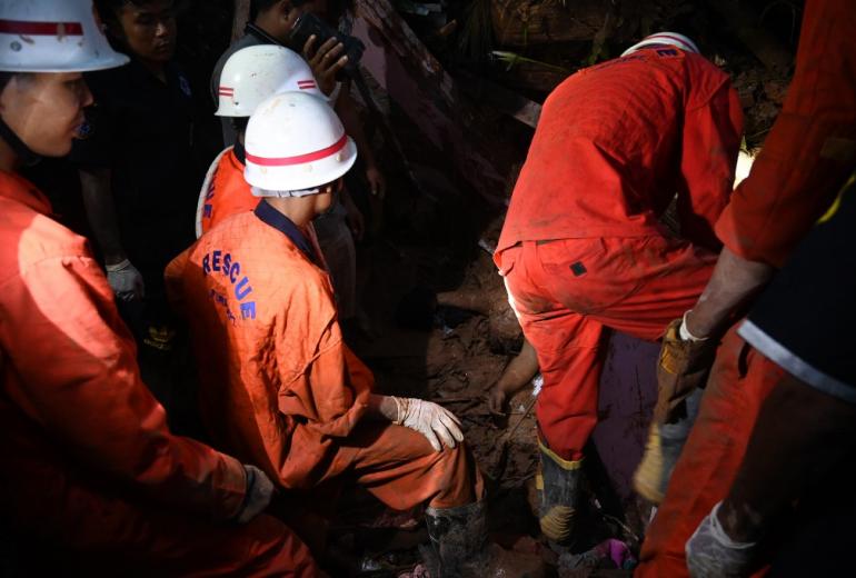  Rescue workers attempt to extricate the body of a landslide victim from debris in Paung township, Mon state on August 9, 2019. (Ye Aung Thu / AFP)