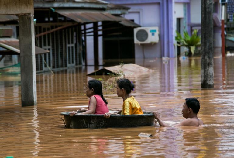  Residents use a plastic tub as floodwaters submerged areas of Ye township in Mon State on August 11, 2019. (Sai Aung Main / AFP)