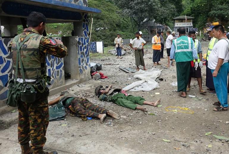 People look at bodies lying on the ground in the compound of the Gote Twin police station in Shan state on August 15, 2019, after it was attacked by ethnic rebel groups. (STR / AFP)