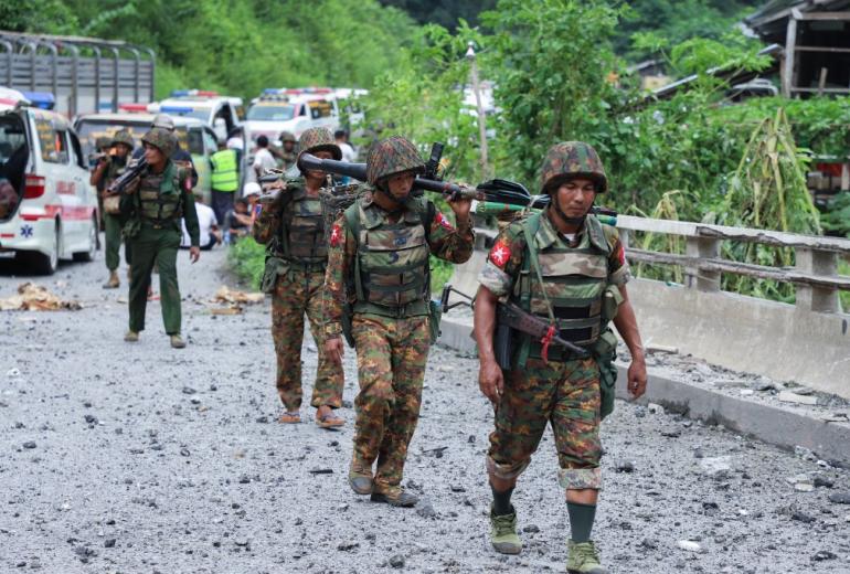 Armed government troops cross a bomb damaged bridge outside the compound of the Gote Twin police station in Shan state on August 15, 2019, after it was attacked by ethnic rebel groups. (STR / AFP)