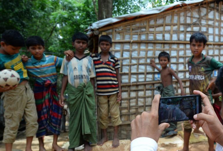  In this picture taken on July 23, 2019, children pose as Rohingya youth Mohammad Rafiq takes their photos with a mobile phone at the Kutupalong refugee camp. (Munir Uz Zaman / AFP)