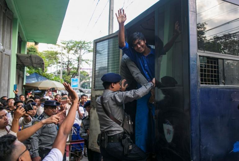 Zayer Lwin, a performer of Peacock Generation group waves from a prison van after a trial in Yangon on November 18, 2019. (Sai Aung Main / AFP)