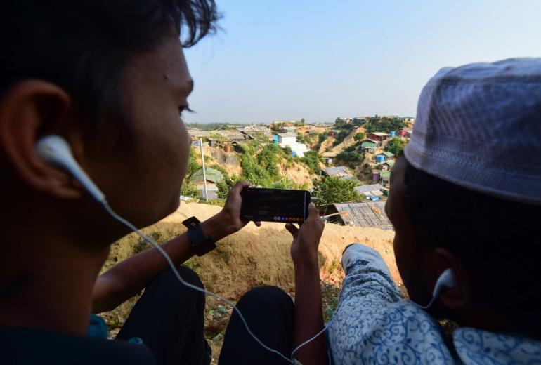 Rohingya refugees watch a livefeed of Myanmar's State Counsellor Aung San Suu Kyi's appearance at the UN's International Court of Justice in The Hague. (Munir Uz Zaman / AFP)