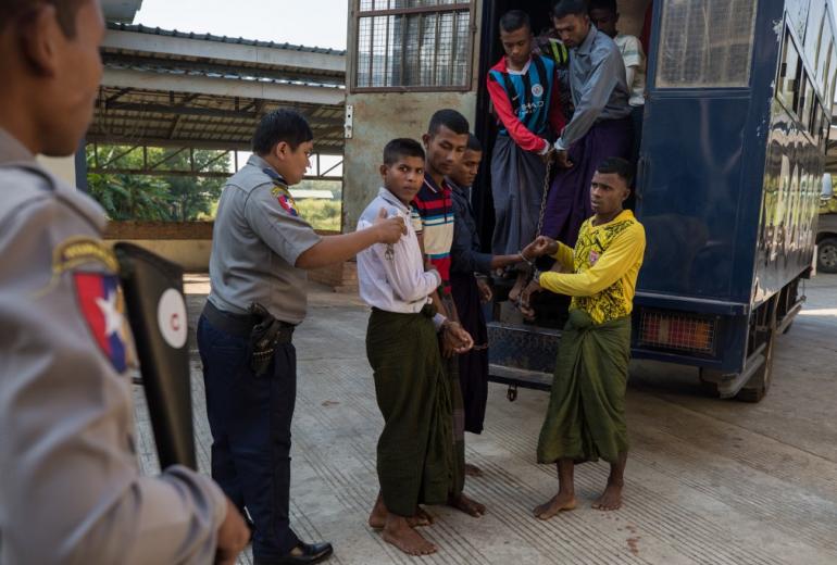 Rohingya detainees step out of a police van upon arriving at the court in the western Myanmar city of Pathein ahead of a hearing on December 11, 2019. (STR / AFP)