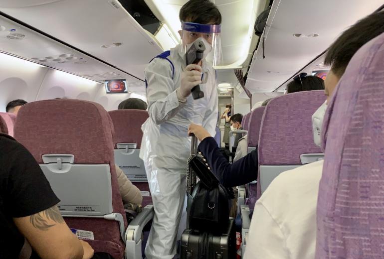 A member of the Myanmar health department wears protective gear as he approaches an airline passenger to check their temperature after the flight landed at Yangon International Airport in Yangon on February 19, 2020. (Sam Yeh / AFP)
