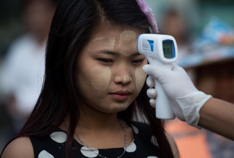 A woman has her temperature taken as a preventive measure against the COVID-19 novel coronavirus at a market in Yangon on March 21, 2020. (Ye Aung Thu / AFP)
