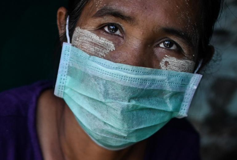 A vendor having thanaka, a traditional facial cosmetic wears a face mask as a preventive measure against the COVID-19 novel coronavirus at a market in Yangon on March 24, 2020.  (Ye Aung Thu / AFP)