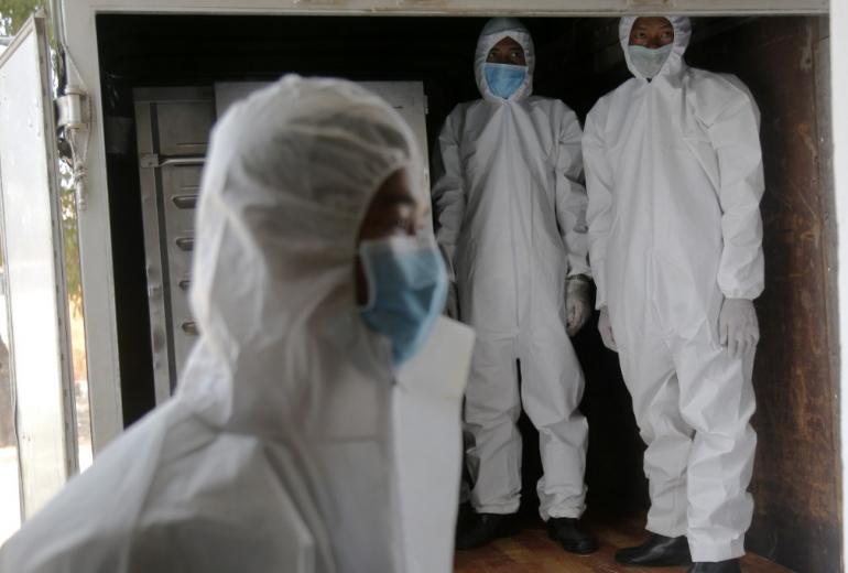 Myanmar military personnel wearing protective clothing prepare food for people confined at a community quarantine centre as a preventive measure against the spread of COVID-19 coronavirus, inside a military camp in Yangon on April 9, 2020. (Sai Aung Main / AFP)