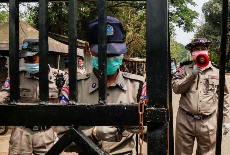 Prison officials, wearing face masks as a preventive measure against the spread of the COVID-19 novel coronavirus, stand guard in front of Insein Prison. (Sai Aung Main)