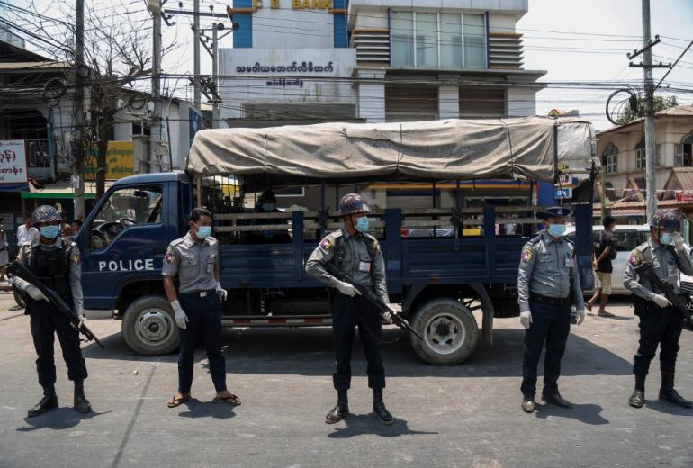 Police, wearing face masks as a preventive measure against the spread of the COVID-19 novel coronavirus, stand guard during a prisoner release in front of Insein Prison in Yangon on April 17, 2020. (Sai Aung Main / AFP)