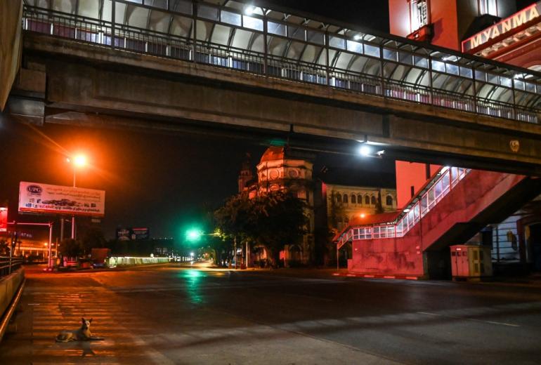 This photo taken on April 16, 2020 shows a dog (bottom L) resting on a deserted road in Yangon. The Yangon government announced a 10pm to 4am curfew to begin on April 18 amid fears of the COVID-19 coronavirus pandemic. (Ye Aung Thu / AFP)