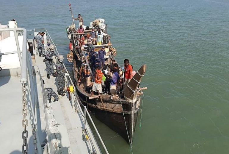 In this picture taken on May 2, 2020, Rohingya refugees stranded at sea are seen on a boat near the coast of Cox's Bazar. Dozens of Rohingya refugees believed to have come from two boats stranded at sea for weeks as they tried to reach Malaysia landed on the Bangladesh coast on May 2, Rohingya community leaders said. (STR / AFP)