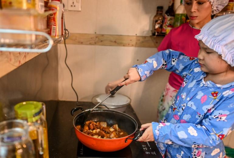  This photo taken on May 21, 2020 shows Moe Myint May Thu (R) and her mother Honey Cho cooking while filming a video at their house in Yangon. (Ye Aung Thu / AFP)