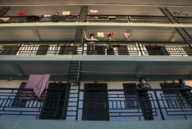 People in quarantine suspected of having the Covid-19 coronavirus wait for food delivered by volunteers at a medical facility in Myanmar on October 12, 2020. (Sai Aung Main / AFP)