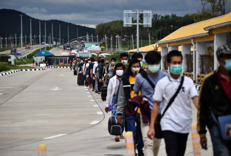 People line up to have their temperatures taken as a preventive measure against the spread of the COVID-19 novel coronavirus at the Ministry of Transport at the border crossing over the second Thailand-Myanmar Friendship Bridge in Mae Sot in Tak province on October 29, 2020. (Lillian Suwanrumpha / AFP)