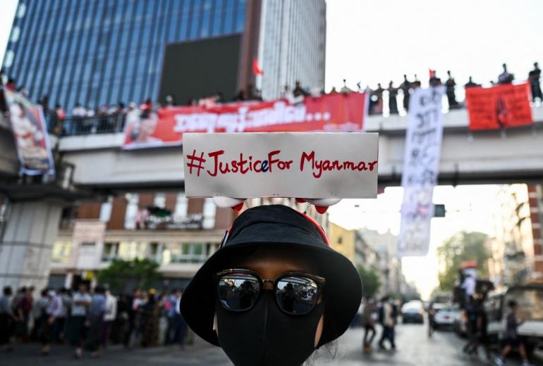 A protester wears a sign with a hashtag #justiceformyanmar as they take part in a demonstration against the military coup in Yangon on February 8, 2021. (Ye Aung Thu / AFP)