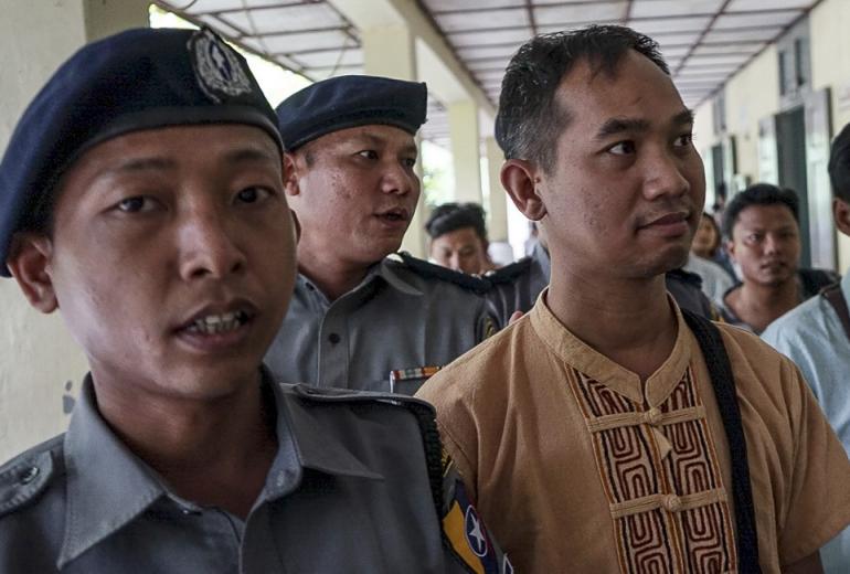 Swe Win (C), the editor of Myanmar Now, is escorted to a court by police in Mandalay on July 31, 2017. (AFP)