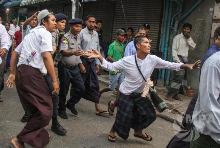 Crowd members allegedly tried to hurt Ko Aung Myint as he was taken to the police station in handcuffs (Photo- MPA)