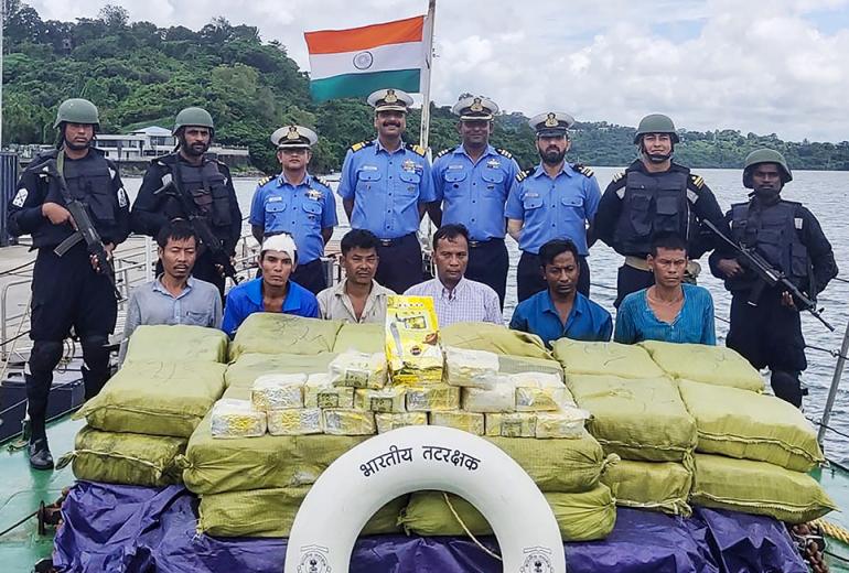 In this handout photograph taken by India's Ministry of Defence on September 19, 2019, Indian Coast Guard personnel (up) pose for photographs as they keep watch on a Myanmar ship's crew after seizing 1160 kg of Ketamine drug from their boat near Car Nicobar islands, part of the Indian union territory of Andaman and Nicobar islands. (AFP / handout)