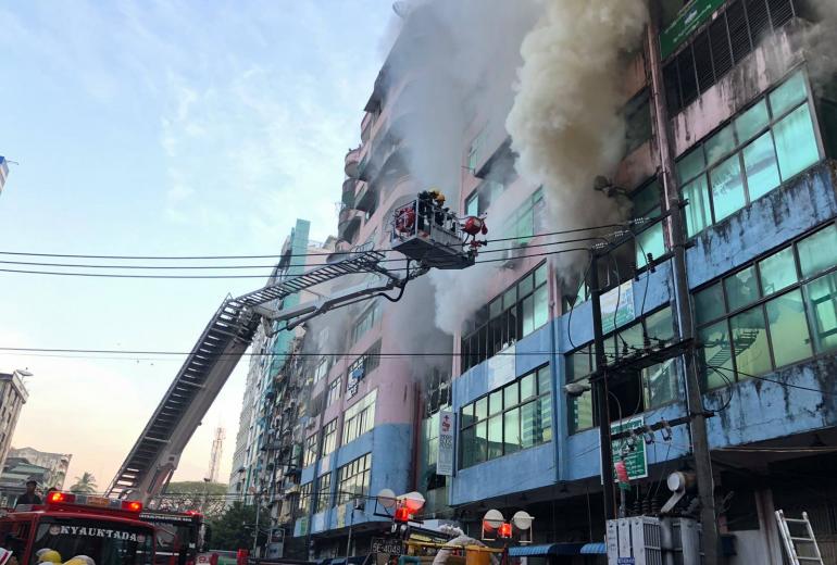 Smoke billows from an apartment block and market in Yangon's Lanmadaw township. (Myanmar Fire Services Department / Facebook)