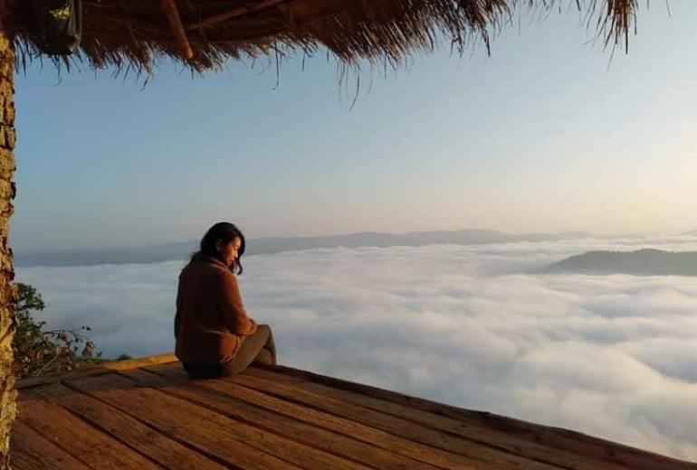 A visitor sits above a blanket of clouds at Cloudy Villa in northern Shan State. (Cloudy Villa / Facebook)