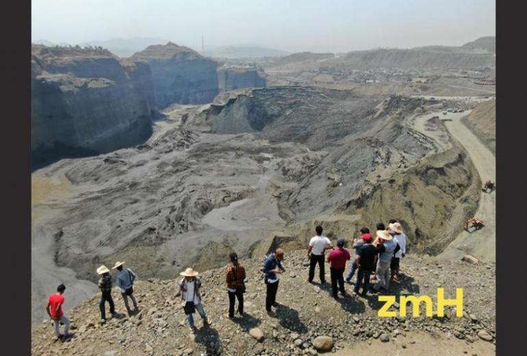   Observers look at the worksite that was flooded with mud after the dam breach on the outskirts of Kachin state's Hpakant township. (Zaw Moe Htet)