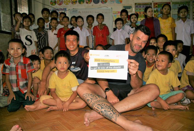 Kyaw Min Naing and Jochen Meissner with some of the children supported by SONNE Social Organisation. (Supplied)