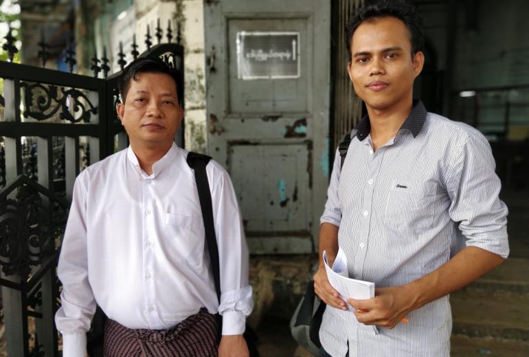 Journalist Moe Myint, right, stands in front of the Kyauktada township court with defence lawyer Than Zaw Aung on Wednesday. (Myanmar Now) 