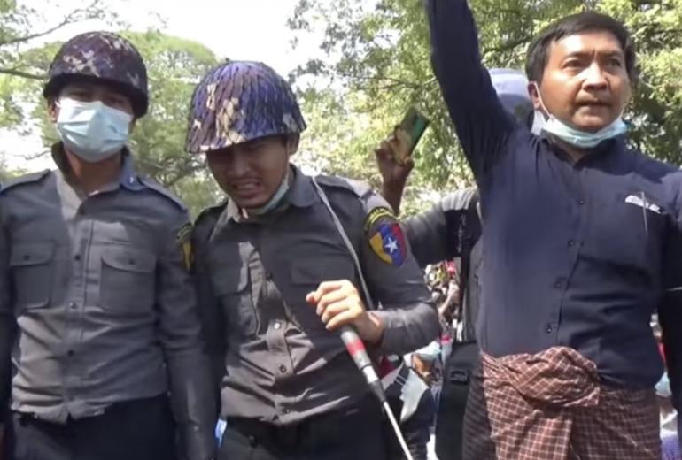 A police officer who joined protesters in Magway town speaks to the rally. The town saw the dramatic moment three police officers turned to face the water cannon in order to shield protesters from the blast on February 9. (Screenshot)