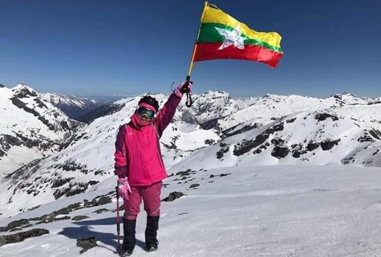 Saint Htet holds the Myanmar flag on Mount Phangran Razi. (The Summiter Group / Facebook)