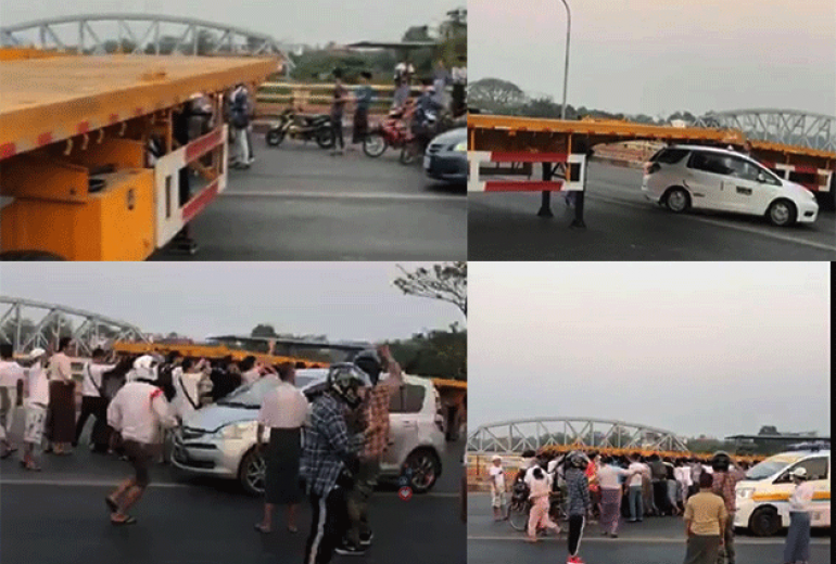 People push a truck trailer blocking the way to Yangon. (Supplied)