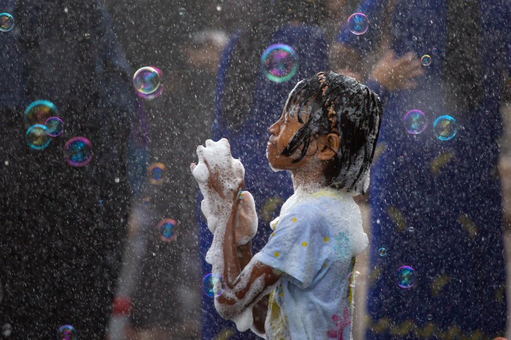 A girl plays with soap suds during celebrations for the Buddhist New Year.  (Sai Aung / AFP)