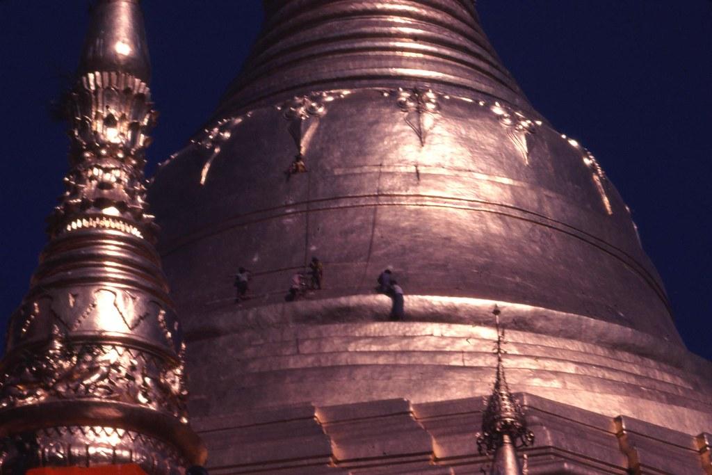 Workers climb the huge structure of Shwedagon padoga.