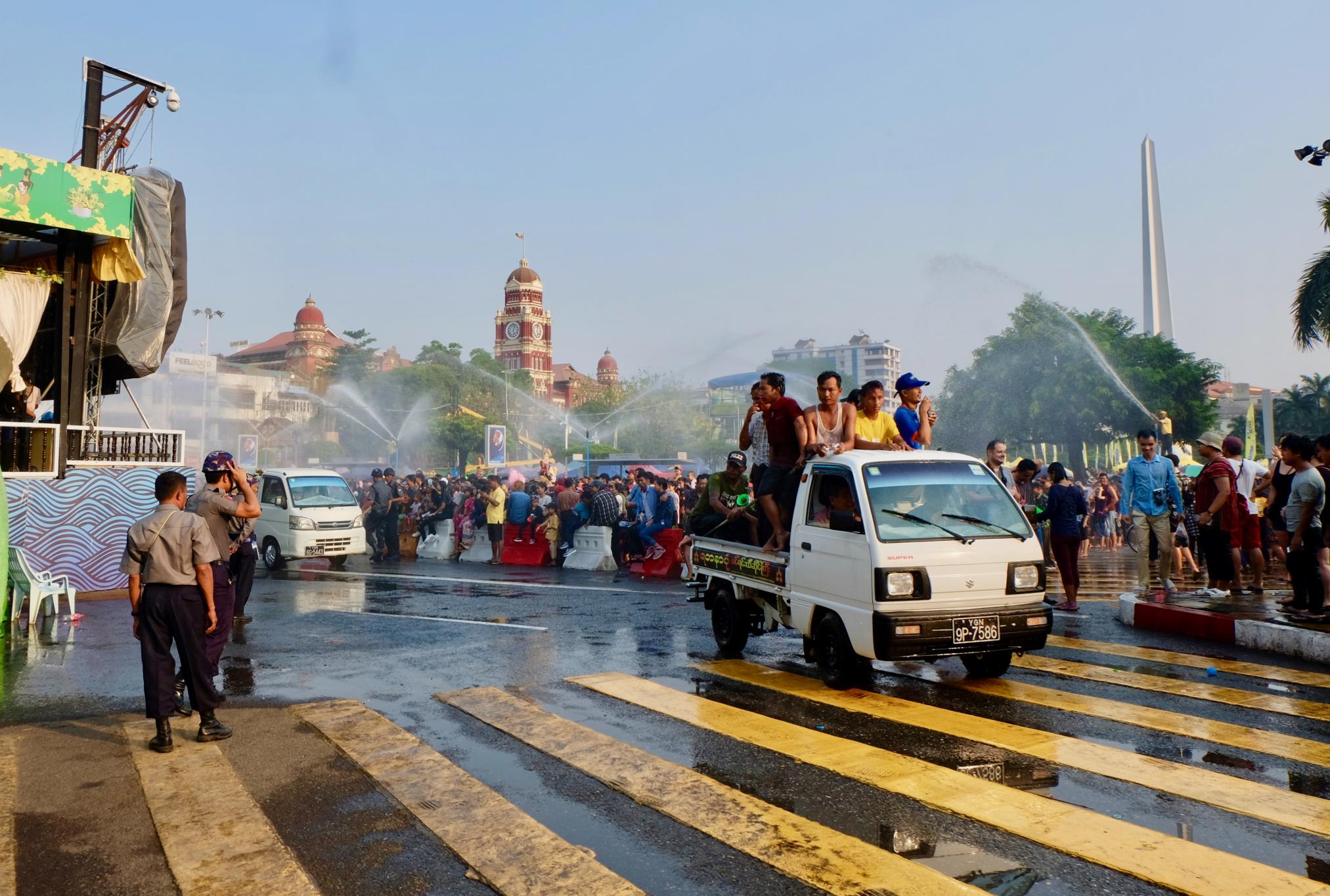 A truck gets hosed as it drives past a crowd in downtown Yangon. (Myanmar Mix)