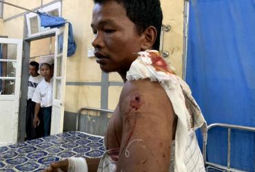 An injured man from Kyauk Tan village in Rathedaung township sits on a bed in a hospital in Rakhine state's capital Sittwe in western Myanmar on May 2, 2019, after the army opened fire on a group of ethnic Rakhine detainees at a school in the village (STR / AFP).