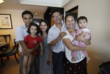 Reuters journalist Wa Lone (3rd R) poses with his wife Pan Ei Mon (2nd R) and daughter along with his colleague Kyaw Soe Oo (L) carrying his daughter and his wife Chit Su Win after being freed from prison in a presidential amnesty in Yangon on May 7. (Ann Wang / AFP)
