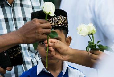 Buddhists give white roses to Muslims as they attend prayers during Eid al-Fitr at Thanlyin township on the outskirts of Yangon on June 5, 2019. (Sai Aung Main / AFP)