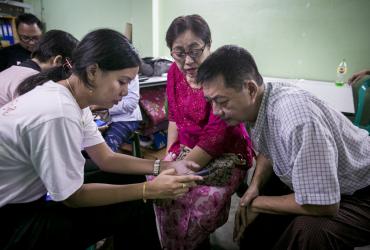  This photograph taken on September 22, 2019 shows Myanmar information technology volunteers assisting mobile phone users switching from the old Zawgyi font to the unicode font in Yangon. (Sai Aung Main / AFP)