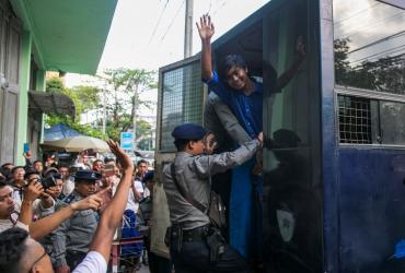 Zayer Lwin, a performer of Peacock Generation group waves from a prison van after a trial in Yangon on November 18, 2019. (Sai Aung Main / AFP)