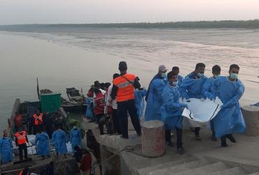 Rescue workers carry a dead body (R) following a boat capsizing accident, in Teknaf on February 11, 2020. (STR / AFP)