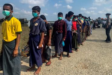 Released Rohingya prisoners wearing face masks amid concerns of the COVID-19 coronavirus pandemic arrive in Sittwe jetty in Rakhine State after being transported by military boat on April 20, 2020. Myanmar sent more than 800 Rohingya back to its restive Rakhine state April 20 after releasing them from various overcrowded jails as the country, accused of genocide against the minority, tries to grapple with the coronavirus crisis. (STR / AFP)
