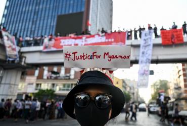 A protester wears a sign with a hashtag #justiceformyanmar as they take part in a demonstration against the military coup in Yangon on February 8, 2021. (Ye Aung Thu / AFP)