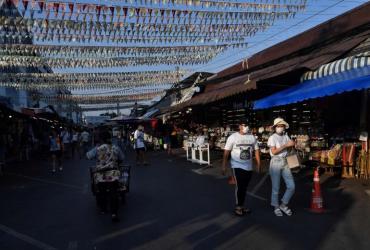 People in face masks walk through an unusually empty Chatuchak weekend market in Bangkok, on March 21, 2020. (AFP)