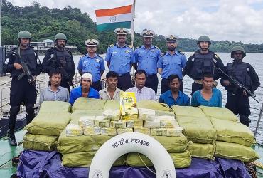 In this handout photograph taken by India's Ministry of Defence on September 19, 2019, Indian Coast Guard personnel (up) pose for photographs as they keep watch on a Myanmar ship's crew after seizing 1160 kg of Ketamine drug from their boat near Car Nicobar islands, part of the Indian union territory of Andaman and Nicobar islands. (AFP / handout)