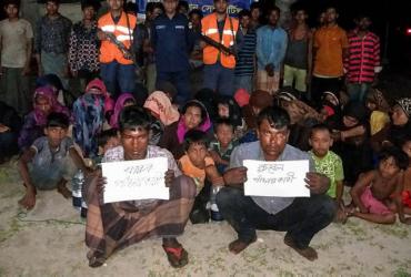 Bangladesh Coast Guard pose for a photo with rescued Rohingya refugees in Teknaf on May 31, 2019. (AFP)