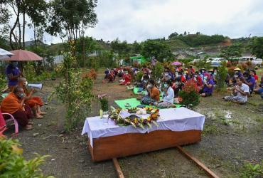 Htar Htar Myint (C) paying respect beside a coffin for her husband's funeral ceremony, following a deadly landslide in an area of open-cast jade mines, near Hpakant. (Ye Aung Thu / AFP)