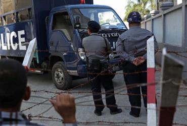 Myanmar police stand near a police van outside court. (Myo Min Soe / AFP)