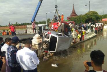 A crane truck lifts the vehicle that crashed into the moat of Mandalay Palace on 25 August. (Zaw Lin Oo)