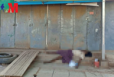 In this photograph published by Voice of Myanmar, the atrophied limbs of a dead man hang over steps at a bus terminal in central Myanmar. A waste collector, police say he died of malnutrition after recycling shops closed due to Covid-19. 