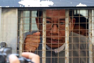 Aye Maung, Ann Township MP and former Arakan National Party leader, speaks to the media as he is escorted out of court after his hearing in Sittwe, Rakhine on March 19, 2019. (STR / AFP)